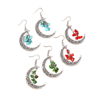 Set of moon-shaped earrings with turquoise, red, and green stones on a beige background.