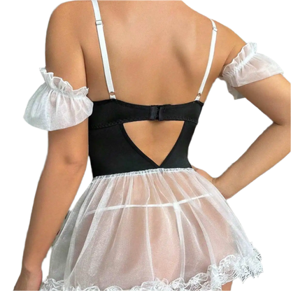 Person wearing a black top with a sheer white skirt in an indoor setting