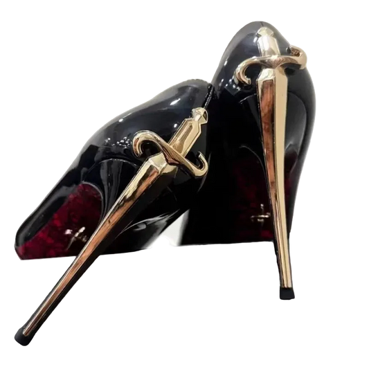 Black high-heeled shoes with gold sword designs on a white background
