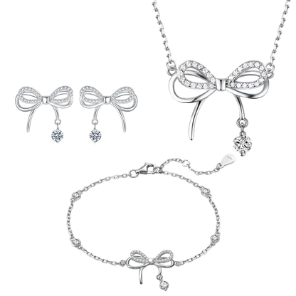 Silver bow-shaped jewelry set including necklace, earrings, and bracelet on a white background