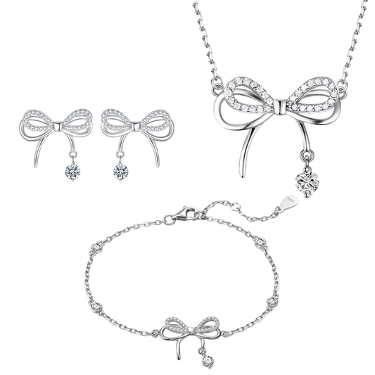 Silver bow-shaped jewelry set including necklace, earrings, and bracelet on a white background