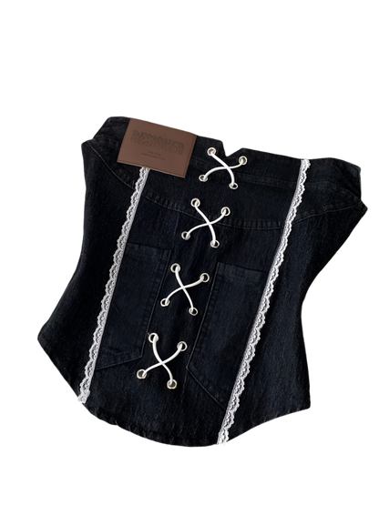 Black denim vest with lace details on a white surface