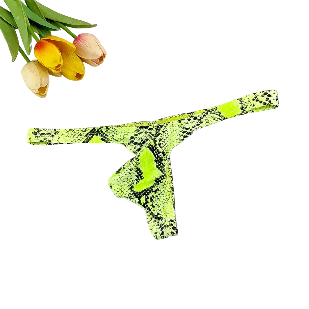 A neon green and black snakeskin-print thong laid flat on a dark surface, with tulips and a white grid tile as styled props.