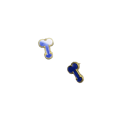 Two small bone-shaped stud earrings with blue enamel and gold-tone edges, displayed on a dark textured surface with one earring resting on a black rectangular stand.