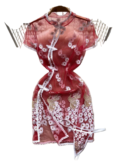 Red lace dress on a white fur surface with floral decorations in the background