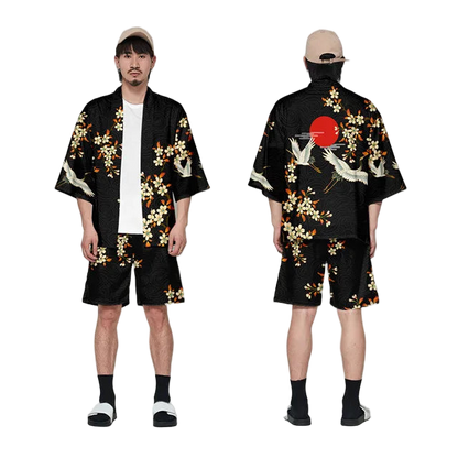 Person wearing a black kimono with floral and crane designs, standing against a white background.