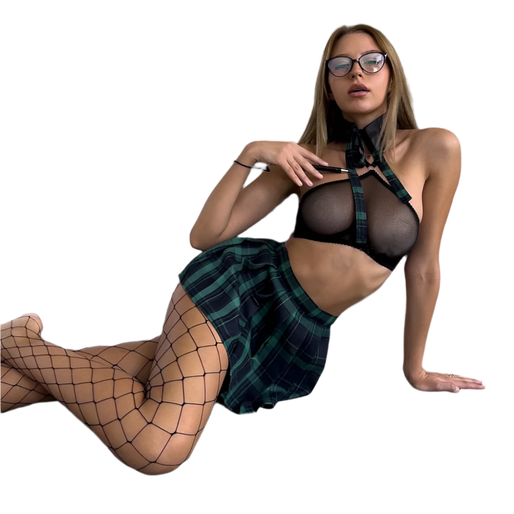 Woman in fishnet stockings and plaid skirt posing on a concrete floor.