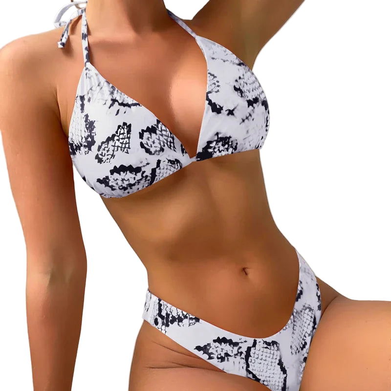 Person wearing a white bikini with black pattern against a neutral background