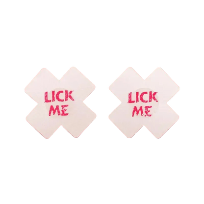 Two white diamond-shaped coasters with 'LICK ME' text on a pink background
