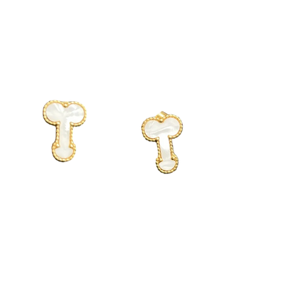 A pair of small gold-tone stud earrings with white enamel details, displayed on a textured black surface.