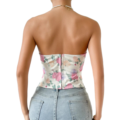 Person wearing a floral strapless top and denim shorts against a white background