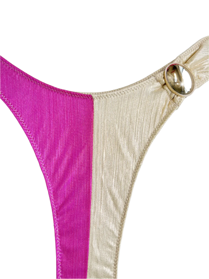 A bikini set with a one-shoulder design, featuring a combination of pink and cream colors. The pieces are accented with decorative gold rings.