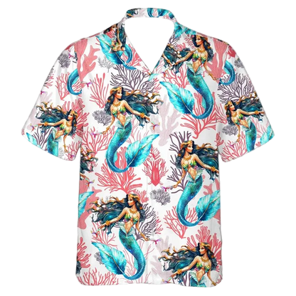 A short-sleeve button-up Hawaiian-style shirt with a white base and an all-over print of mermaids and coral. The mermaids have teal-blue tails, dark hair, and swimwear in pink, green, and yellow tones, set against a white background with coral in pink, red, and gray.