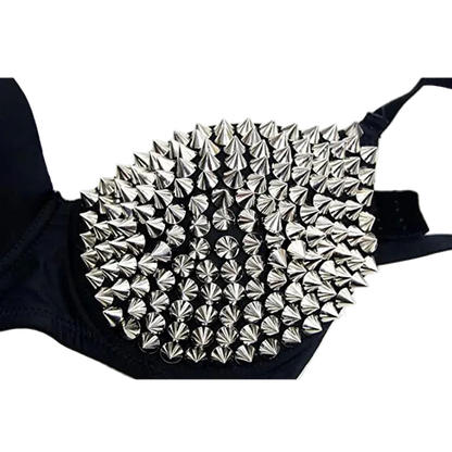 A close-up of a black bra cup heavily decorated with metallic silver conical spikes, shown against a plain white background.