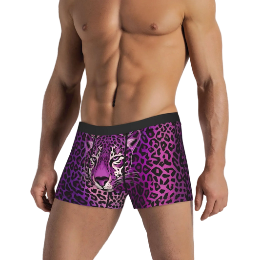 A man wearing men's boxer briefs with a purple and black leopard print and a realistic purple tiger face graphic on the front, set against a white paneled wall.