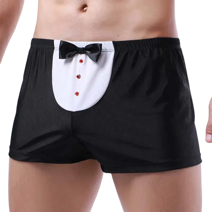 Black boxer briefs with a tuxedo-style front panel featuring a white yoke, black bow tie, and red decorative buttons, shown on a cropped male model against a white studio background.