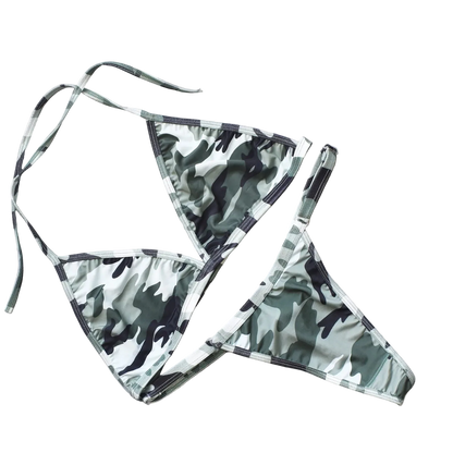 Camouflage bikini set on a light gray surface with decorative elements.