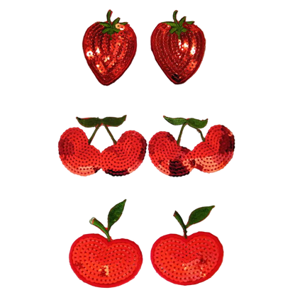 Set of red sequin strawberry and apple decorations on a white background