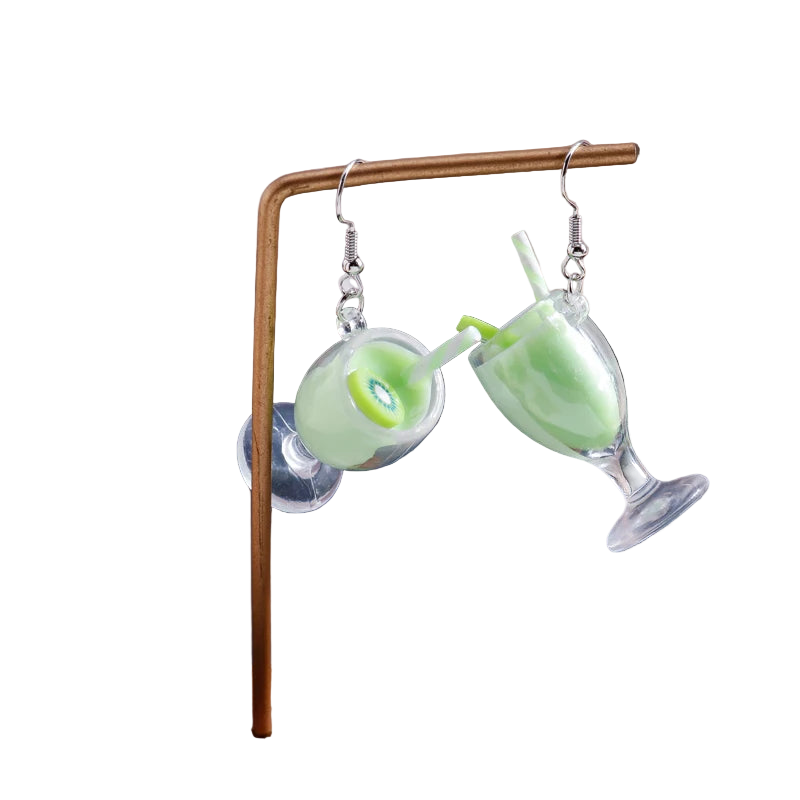 Green cocktail-themed earrings on a wooden stand with a blurred background