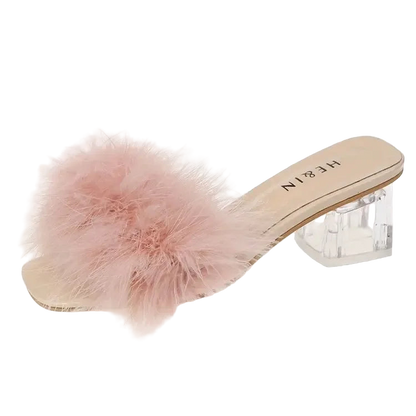 Pink fuzzy slide sandal with clear heel on a white background