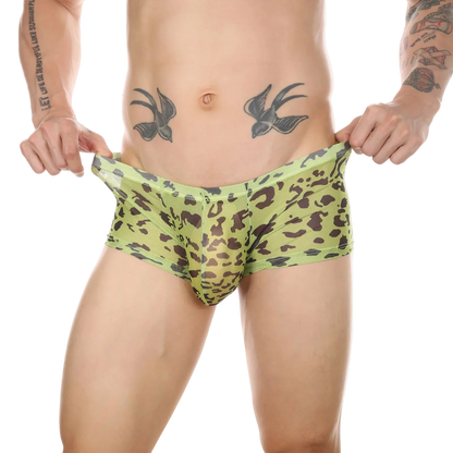 A man wearing low-rise boxer briefs with a green and brown leopard print, holding the waistband outwards to show the fit against a white background.