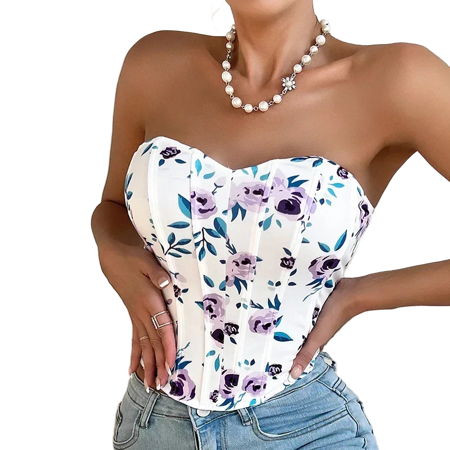 Woman wearing a strapless floral top and jeans with a plain background