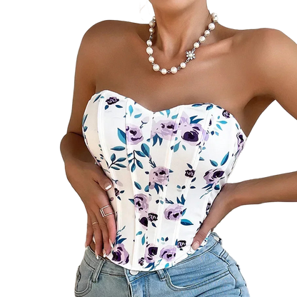 Woman wearing a strapless floral top and jeans with a plain background