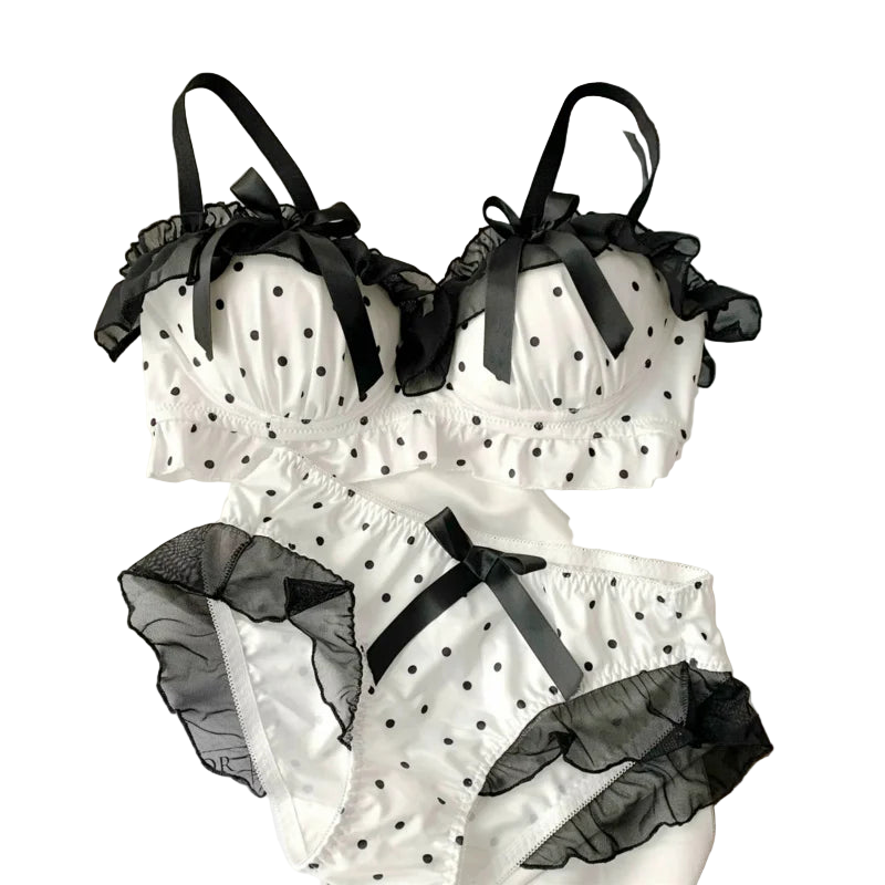White polka dot lingerie set with black accents on a white surface.
