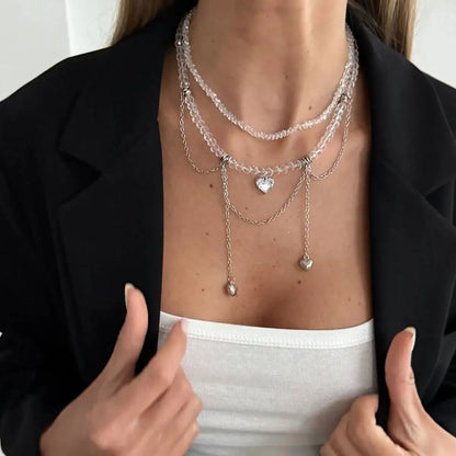 Person wearing multiple necklaces with a focus on the jewelry.