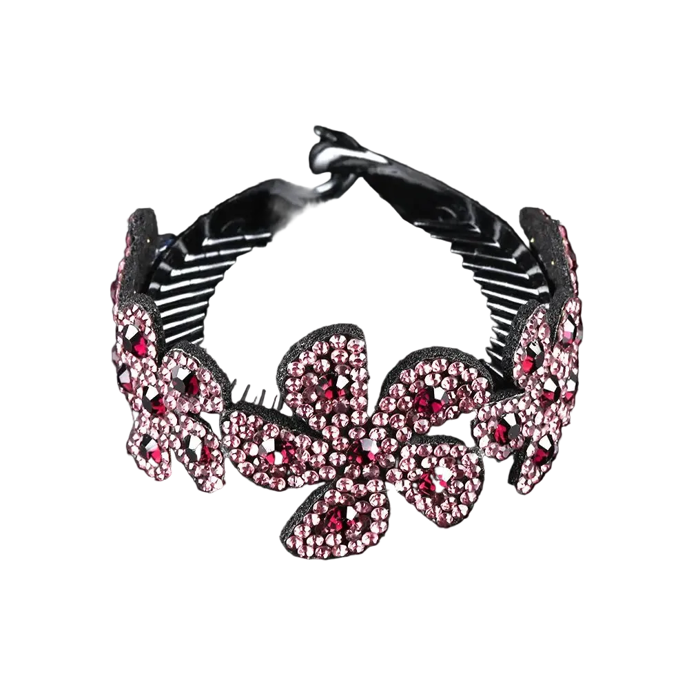A black hair claw clip embellished with pink rhinestones in a floral pattern, shown against a solid black background.