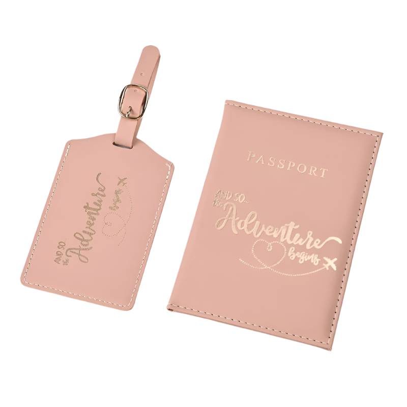 A passport holder and luggage tag set with the phrase "And so the adventure begins" in elegant script. The design is sleek and stylish, perfect for travel.