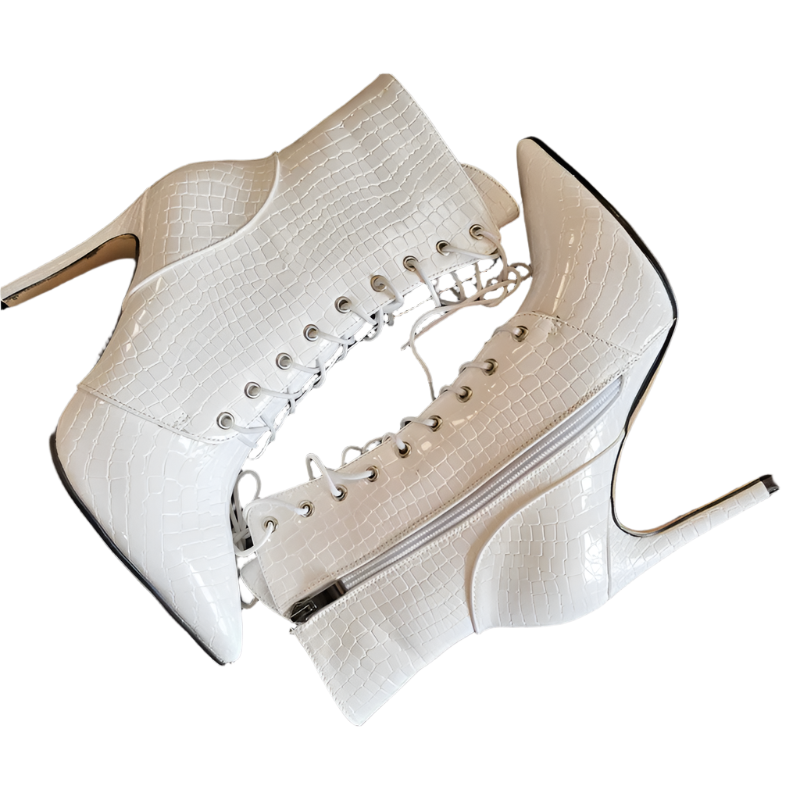 White high-heeled shoes with lace-up design on a dark surface