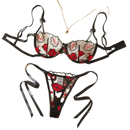 Black lace lingerie set with floral designs on a light background