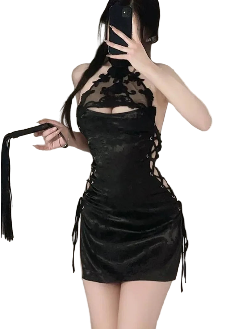 Person wearing a black lace dress with a plain background