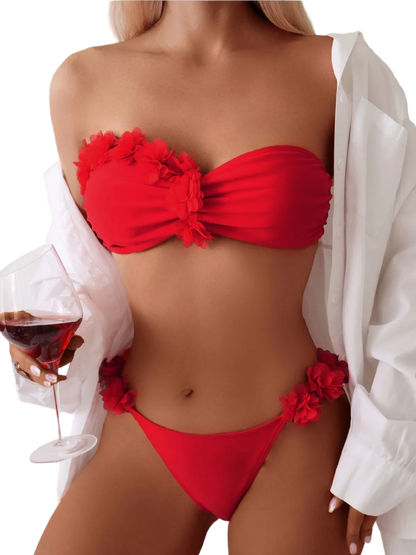 Red bikini with floral details worn by a person holding a glass of red wine.