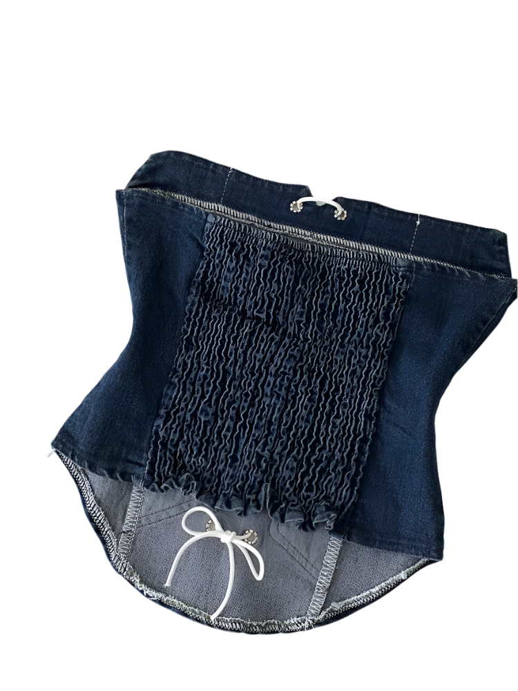 Folded denim shorts with a white drawstring on a light background