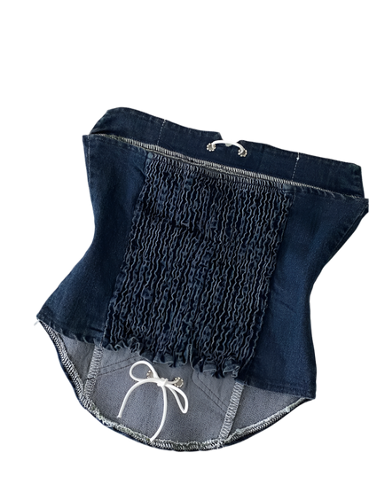 Folded denim shorts with a white drawstring on a light background