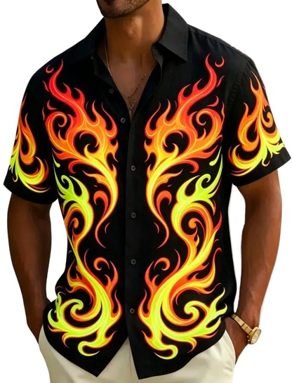 A man wearing a black short-sleeve button-up shirt with a bold flame print in yellow, orange, and red, photographed outdoors with a beach and palm leaves blurred in the background.