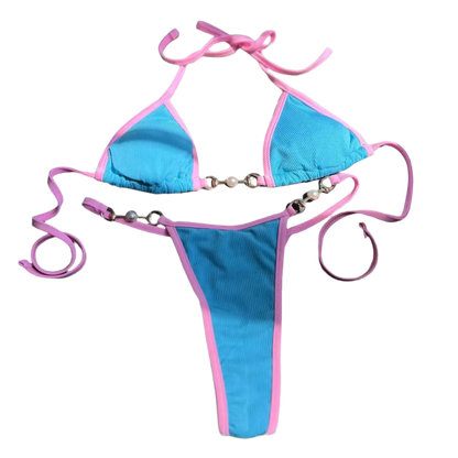 A two tone bikini with chain details. The design is sleek and modern, with a touch of edginess from the metallic accents.
