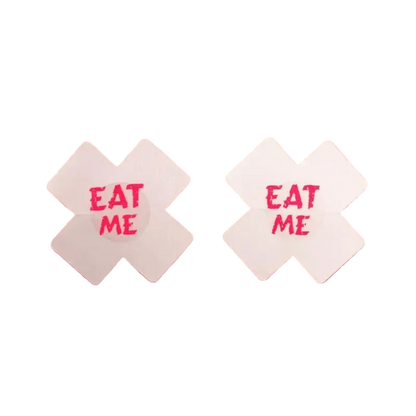 Two white candy wrappers with 'EAT ME' text on a pink background