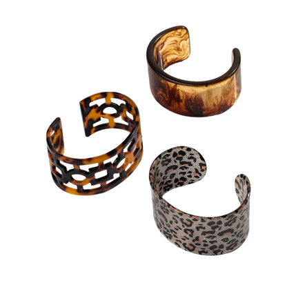 Bold leopard print wide cuff bangle featuring hollow geometric patterns and premium resin design for resort wear and theme nights

