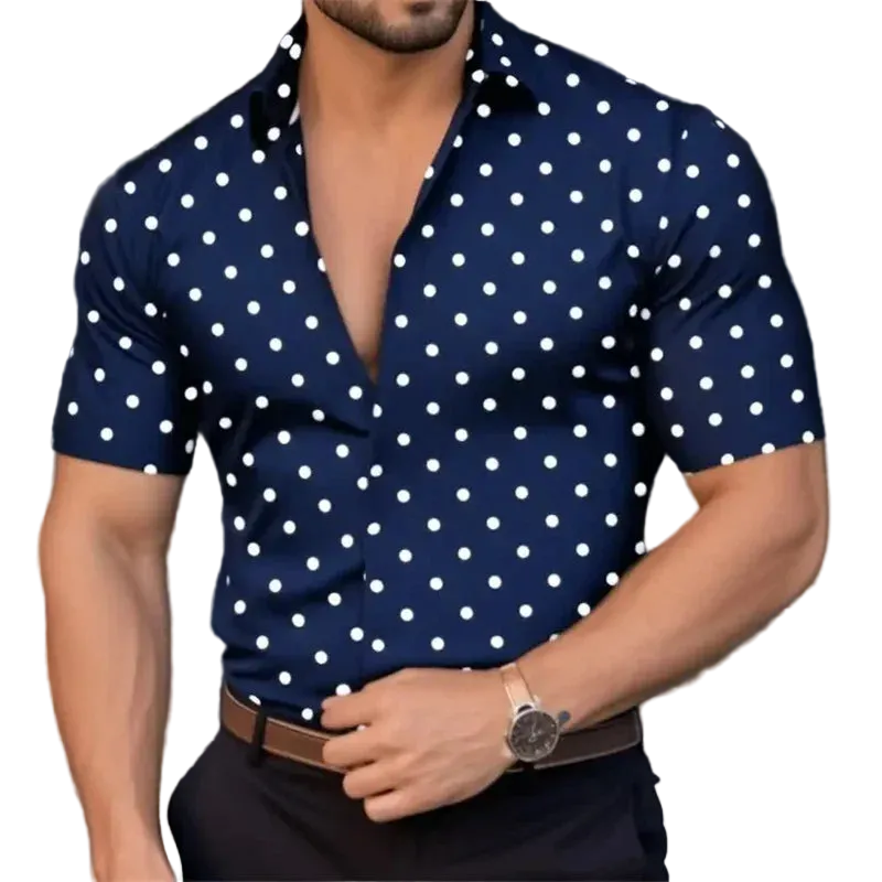 Man wearing a navy blue shirt with white polka dots, standing against a blurred background.